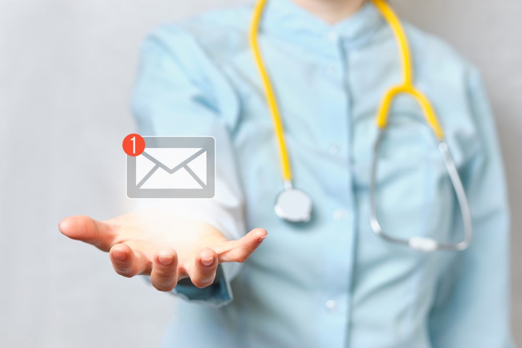 Doctor holds an abstract email with a hand in his hand