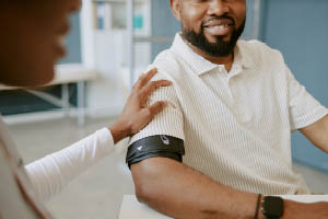 man getting blood pressure check at clinic